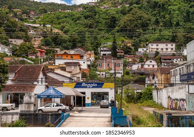Petropolis, Brazil - December 23, 2008: Reggio tires and car repair shop set in its working class neighborhood at lower street with houses built up the green forested hill.