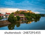 Petrovaradin Fortress next to the city of Novi Sad in Serbia, view from Varadin bridge over Danube river during sunset