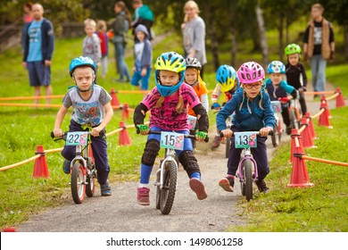 Petrozavodsk, Russia, 2 September 2018: Runbike Summer Cap Competition. Kids Run Bike Race Between Children 2-7 Years Old Sport Groups.  Balance Bike Acceleration Before  Finish On A Difficult Track