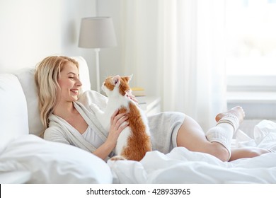 Pets, Morning, Comfort, Rest And People Concept - Happy Young Woman With Cat In Bed At Home