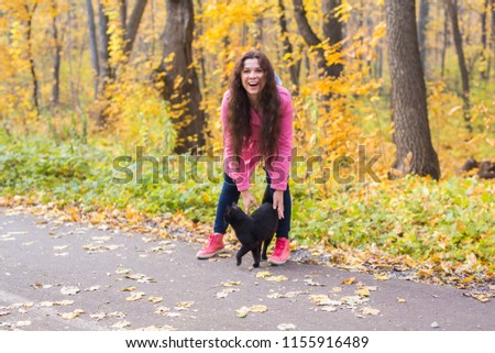 Pets, nature and people concept - Beautiful smiling woman found the black cat