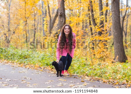 Pets, nature and people concept - Beautiful smiling woman found the black cat