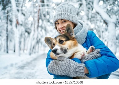 Pets, People And Season Concept. Well Dressed Happy Girl And Corgi Dog Outdoors In Winter