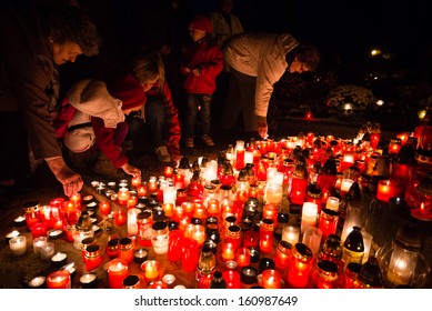 PEZINOK, SLOVAKIA - NOVEMBER 1: People placing candle among candles on ground on All Saints' day on November 1, 2013.