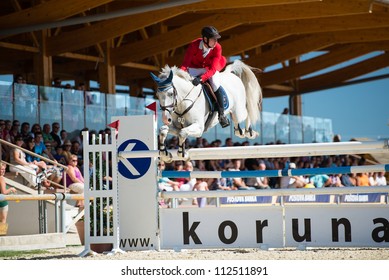 PEZINOK, SLOVAKIA - SEPTEMBER 9: Josef Kincl jr. on horse Cascar jumps over hurdle on Grand Prix Postova Banka-Peugeot on September 9, 2012 in Pezinok, Slovakia
