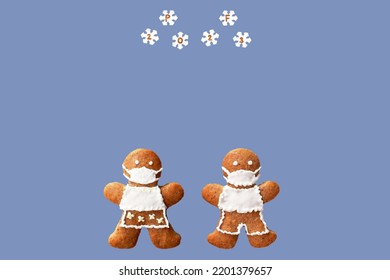 PF 2023 inscribed in snowflakes falling on gingerbread couple with protective face masks. Original New Year greeting card in coronavirus (COVID-19) time, isolated, copy space 