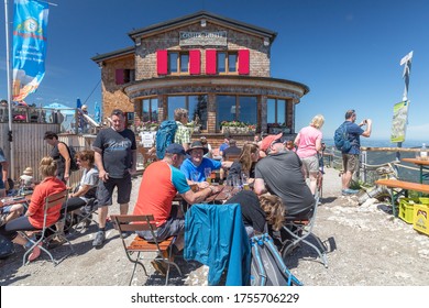 Pfronten, Bavaria / Germany - June 12th 2020, Hikers Eating And Drinking In A Lodge At The Mountain Top During Corona Times Hardly Maintaining Social Distancing