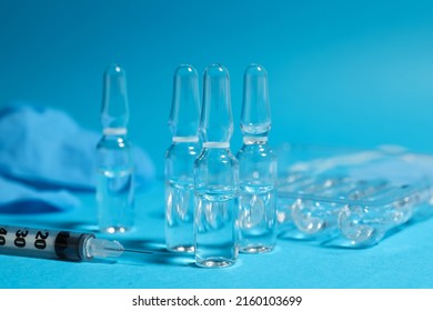 Ampollas y jeringuillas farmacéuticas con fondo azul claro