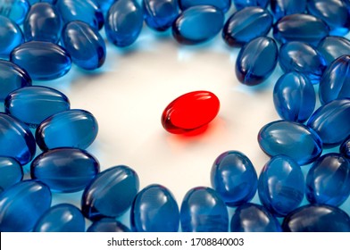 Pharmaceutical Drugs And Visual Metaphor For Leadership Concept With Pile Of Blue Pills Surround The Red Pill On White Background