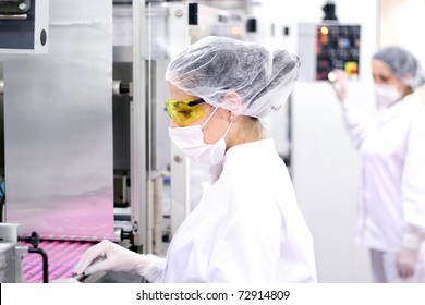 Pharmaceutical Factory Workers. Pharmaceutical Manufacturing. Women working at the Pharmaceutical Factory. Worker Manually Puts Pills in Empty Containers as They Move Along the Conveyor Belt. 