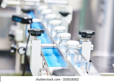 pharmaceutical industry. Production line machine conveyor with glass bottles ampoules at factory, Shallow DOF