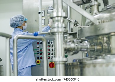 Pharmaceutical Industry Worker at Work. Female worker  Operating Control Panel of the Pharmaceutical Machine. Experimenting and Developing New Medicines in Pharmaceutical lab. Biomedical Research.