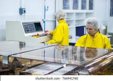 Pharmaceutical Manufacturing Technicians On The Production Line.
Medical Vaccine Manufacturing. Female Workers Beside Ampule Optical Inspection Machine At Pharmaceutical Factory. Two Female Workers.