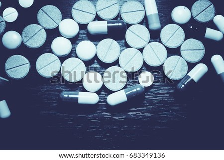 Pharmaceutical medicament, cure in container for health. Pharmacy theme, Heap of green blue white round capsule pills with medicine antibiotic in packages. Drug prescription for treatment medication.