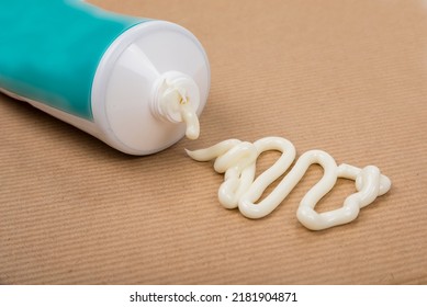 Pharmaceutical medicine or healing topical application ointment concept with plastic tube pushing white cream - Shutterstock ID 2181904871
