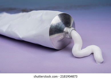 Pharmaceutical medicine or healing topical application ointment concept with plastic tube pushing white cream - Shutterstock ID 2181904873