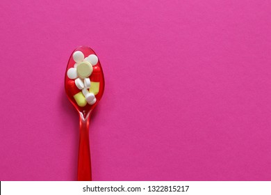 Pharmaceutical medicine pills, tablets and capsules on plastic spoon.  - Shutterstock ID 1322815217