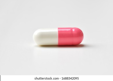 Pharmaceutical medicine pills, tablets and capsules pink-white on white background. Flat lay. Copy space. Medicine concepts. protect colona virus or covid 19. Cure infection. Selected focus