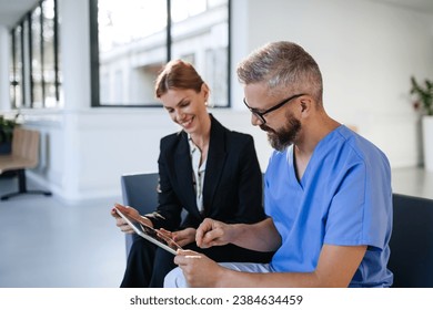 Pharmaceutical sales representative talking with doctor in medical building. Ambitious female sales representative presenting new medication. Woman business leader. - Powered by Shutterstock