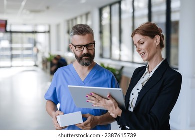 Pharmaceutical sales representative talking with doctor in medical building. Ambitious female sales representative presenting new medication. Woman business leader.