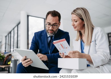 Pharmaceutical sales representative talking with doctor in medical building. Ambitious male sales representative presenting new medication. - Powered by Shutterstock