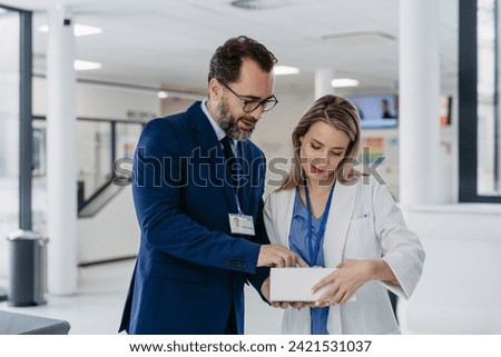 Pharmaceutical sales representative talking with doctor in medical building. Ambitious male sales representative presenting new medication.