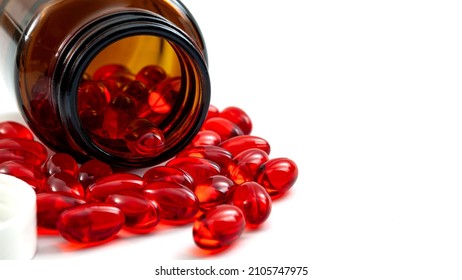 Pharmaceutical Therapy, Pharmacology Medical Treatment And Chronic Pain Management Concept With Transparent Pill Bottle And Many Red Painkiller Pills Spilled Over White Background With Copy Space