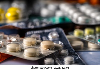 Pharmaceutical various tablets packed in silver blister packs. Close up of white and green pills in package. Bunch of drugs. Vitamins, antibiotics, painkillers. Medicines for treatment of viruses.