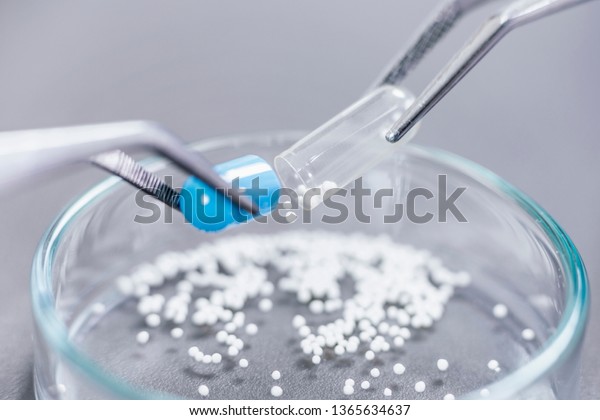 Pharmaceutical Worker Examining Pill.\
Drug tablet being inspected. New Pill Research\
Concept