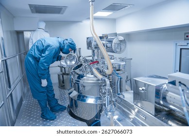 pharmaceutical worker using large machine. person checking medicine liquid making vessel. medicine making factory. person wearing a ppe kit in a factory. healthcare concept. Pharmaceutical industry	