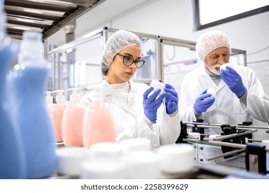 Pharmaceutical workers controlling production of anti-age cream and testing quality. - Shutterstock ID 2258399629