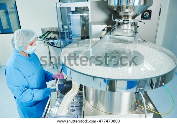 Pharmaceutics. Pharmaceutical worker operates\
tablet blister packaging\
machine
