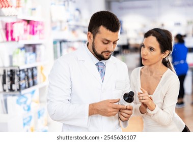 Pharmacist advises customer in a pharmacy, offers medicine for body care - Powered by Shutterstock