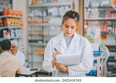 Pharmacist checking Checks Inventory of Medicine, Drugs, Vitamins with tablet and checking patient's prescription in modern pharmacy. - Powered by Shutterstock