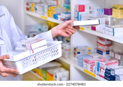 Pharmacist chemist woman standing refills the shelves with new stocks in pharmacy drugstore - Powered by Shutterstock