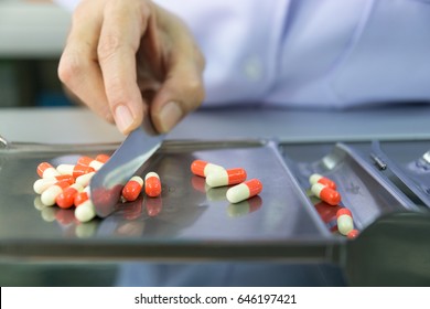 Pharmacist is counting pills on counting drugstore. - Powered by Shutterstock