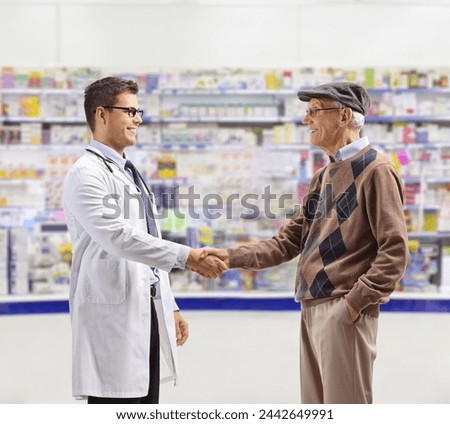 Pharmacist and an elderly man shaking hands inside a chemist store