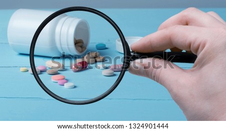 Pharmacist or expert on pharmaceutical inspection identifies pills. Testing, verification and determining pharmaceutical counterfeiting or fakes of medicines and medicinal substance quality concept