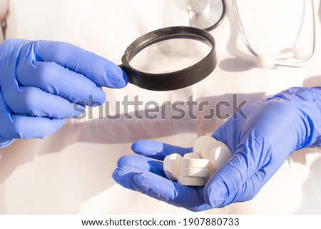 Pharmacist or expert on pharmaceutical inspection identifies pills. Testing, verification and determining pharmaceutical counterfeiting or fakes of medicines