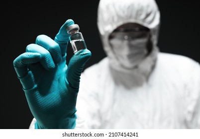 Pharmacist holding Covid-19 vaccine vial, closeup with selective focus