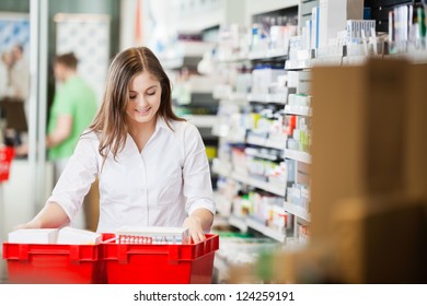 Pharmacist Looking Through Basket Stocking Shelves