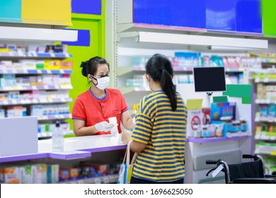 Pharmacist In Medical Face Mask Talking With A Customer At The Pharmacy Desk