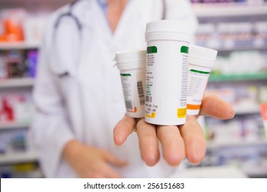 Pharmacist presenting medications on her hand in the pharmacy - Shutterstock ID 256151683