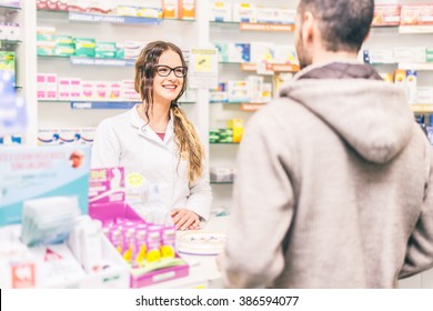 Pharmacist talking with a customer at the pharmacy desk - Powered by Shutterstock