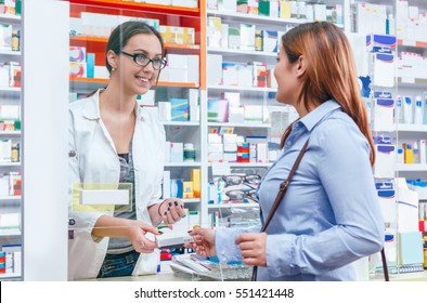Pharmacist Talking With A Customer At The Pharmacy Desk
