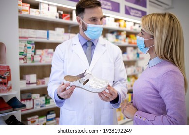 Pharmacist talking to the customer and recommending which shoes to buy.