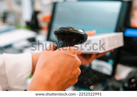 Pharmacist uses barcode reader to identify and sell a drug