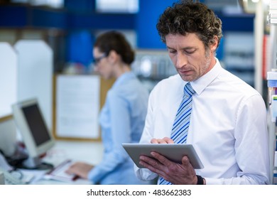 Pharmacist using digital tablet in pharmacy - Shutterstock ID 483662383