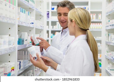 Serious Pharmacists Reaching Medications Among Shelves Stock Photo ...