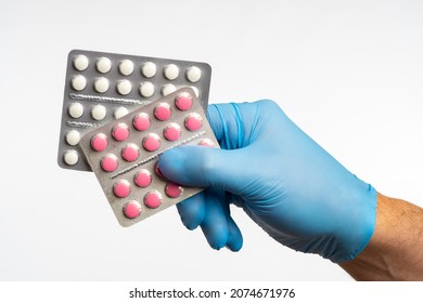 Pharmacologist's hand holds blisters with pills. Tablets on light background. Pharmaceutical industry concept. Pharmaceutical inventions. Making antibiotics in tablets. Pharm industry